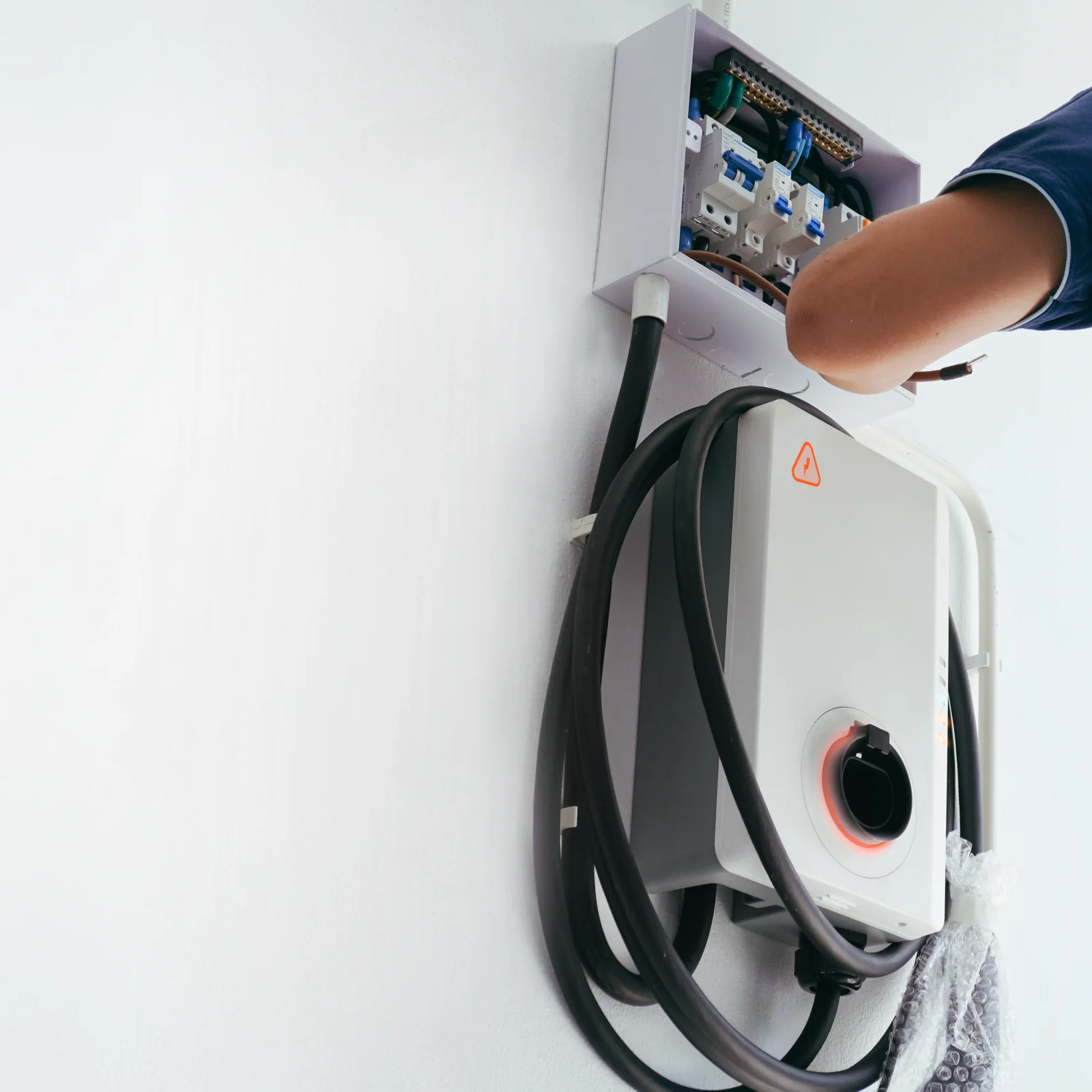 level-2-charger-installation-phoenix-garage-install Level 2 charger installation in Phoenix, Arizona — an electrician wiring the circuit connection for a wall-mounted home EV charger.