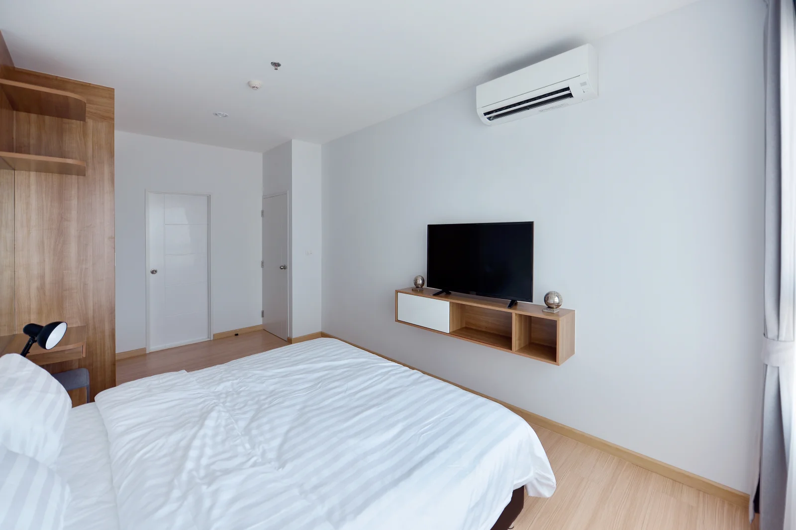 Phoenix mini split install — a ductless indoor wall unit mounted above a bed, providing zoned comfort in a room without existing ductwork.