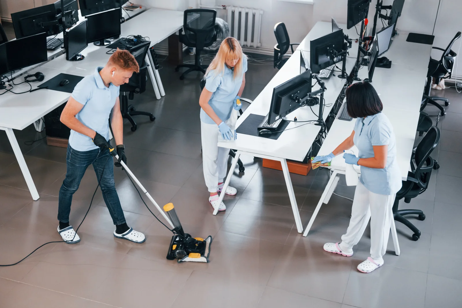 office-cleaning-services-phoenix-az-crew-cleaning-office-floor Office cleaning services in Phoenix, AZ — a team of cleaners in uniform cleaning the floor of a modern office after hours.