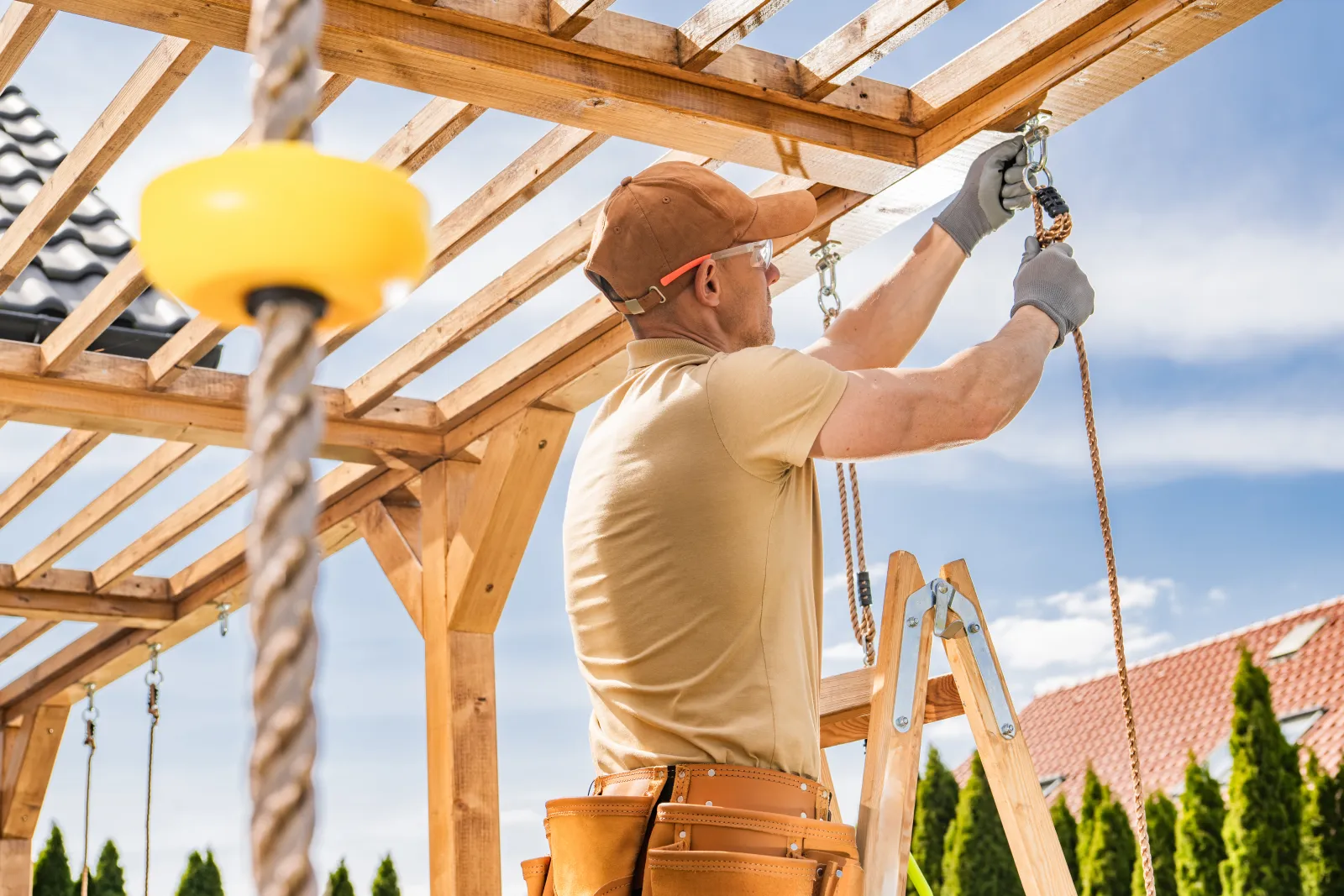pergola-installation-phoenix-build A carpenter assembling and installing a wood pergola frame, setting the posts and rafters that a ShowUp Promise pro builds for a Phoenix backyard.