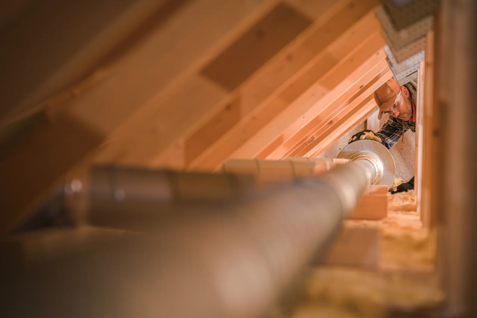 phoenix-duct-cleaning-attic-ductwork Ductwork running through a Phoenix attic where a technician inspects the line for the dust and debris buildup common in the Sonoran Desert climate.