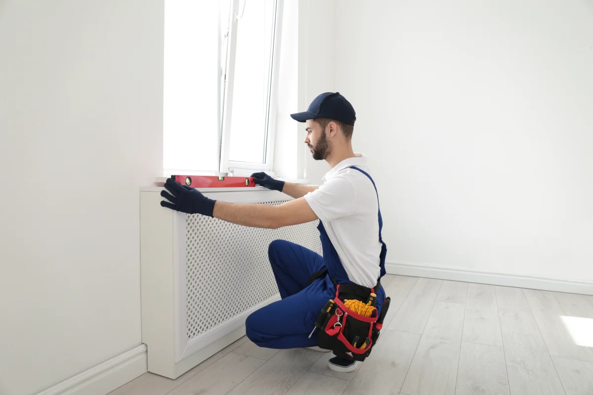 phoenix-finish-carpentry-hero Finish carpentry in Phoenix - a professional carpenter in a tool belt and gloves leveling window trim in a home.