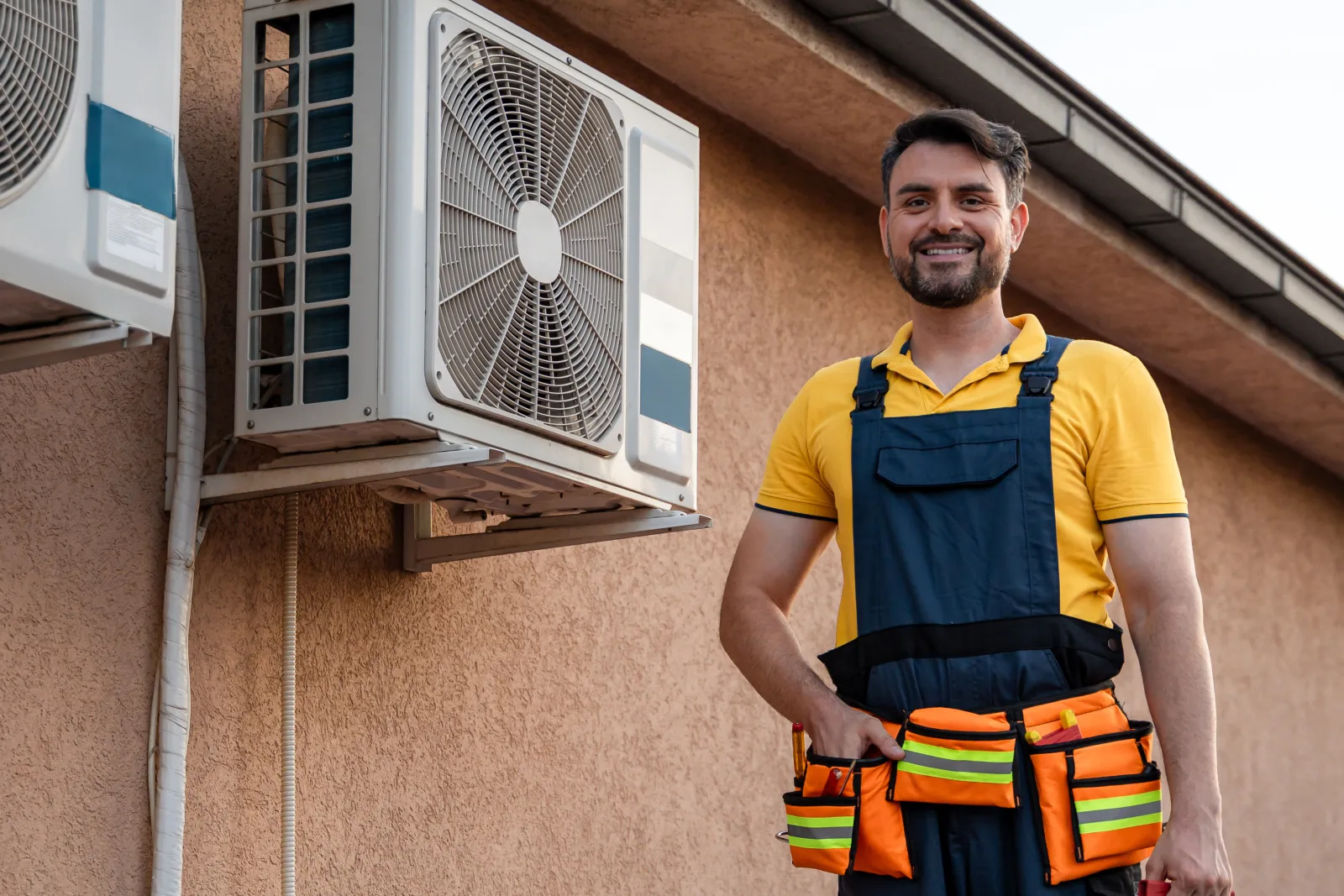 phoenix-hvac-rooftop-heat A uniformed HVAC technician servicing a rooftop air conditioning condenser under harsh Phoenix desert sun.