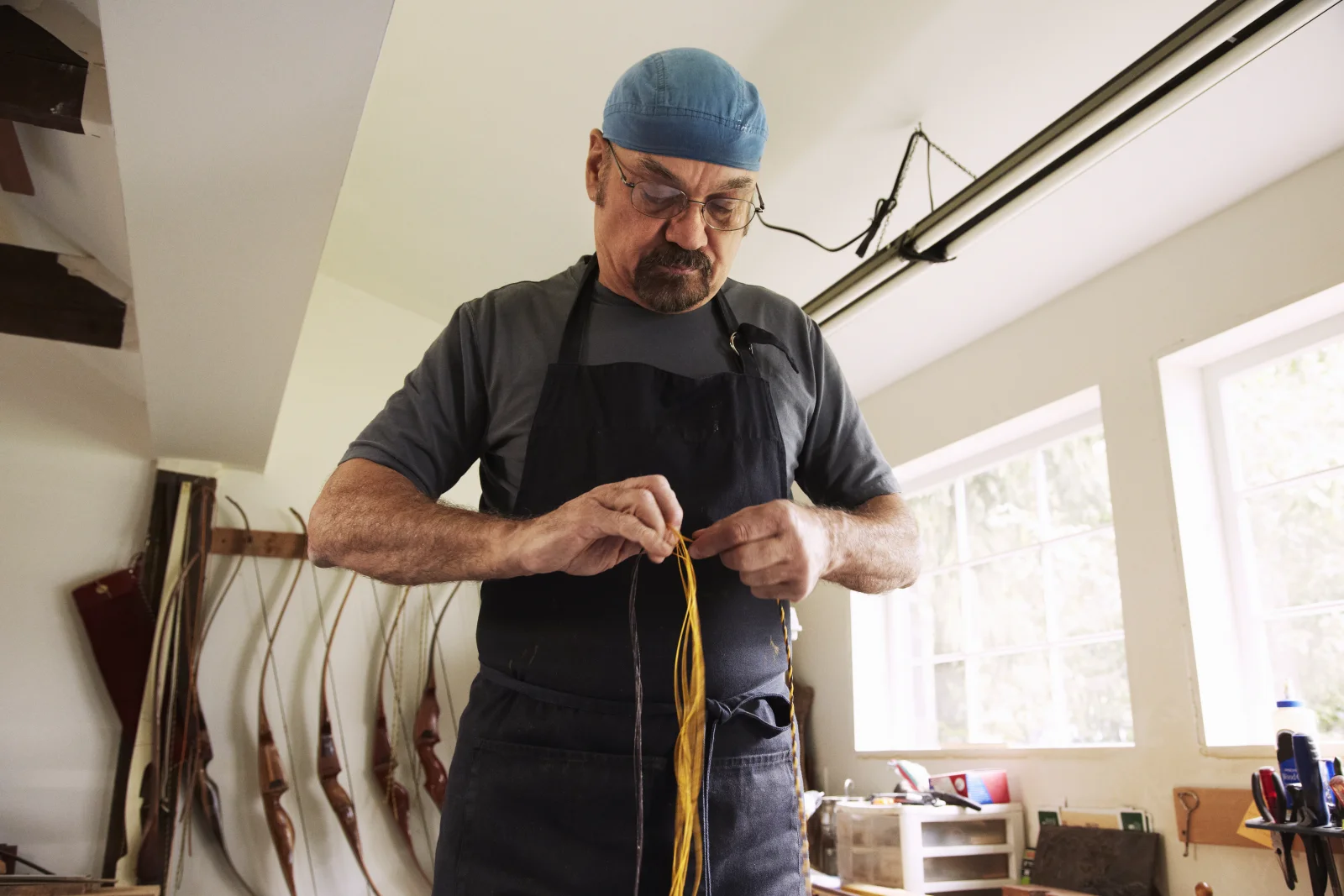 phoenix-millwork-measuring-planning A professional carpenter in a collared work shirt measuring and planning trim placement before cutting custom millwork.