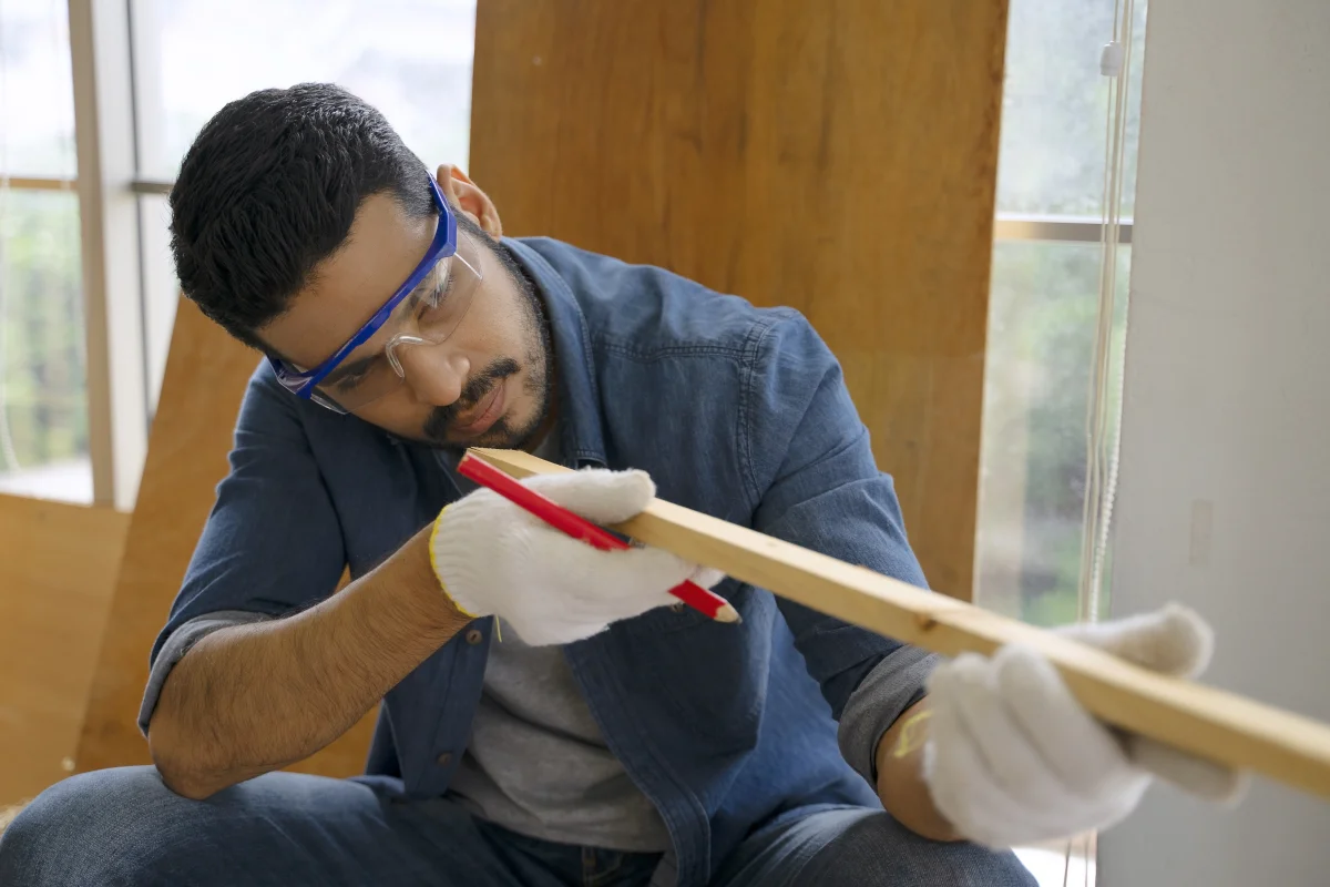 phoenix-millwork-custom-trim-install Phoenix millwork — a carpenter in a collared work shirt installing custom wood trim and cabinetry in a desert-style home.
