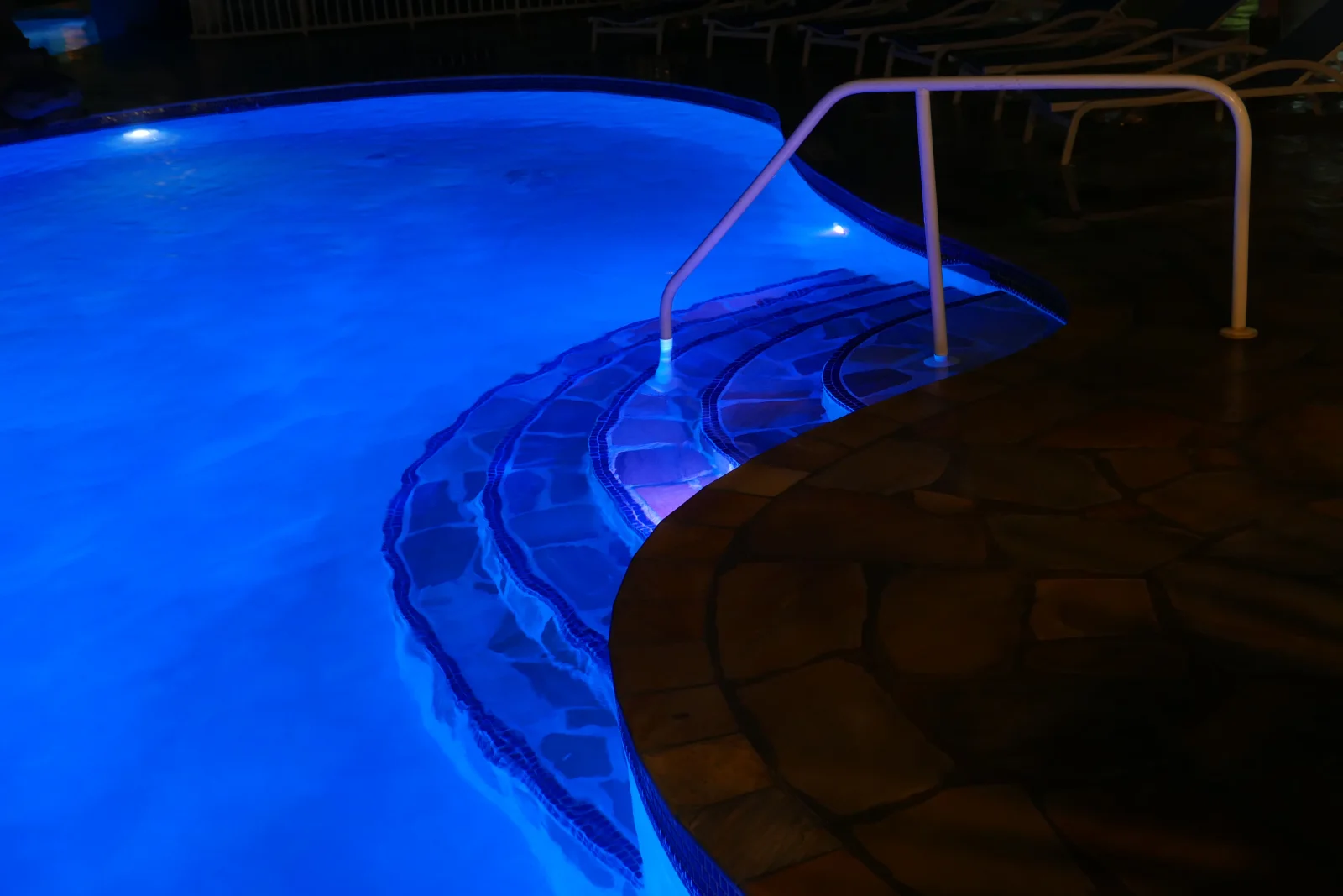 Pool light repair in Phoenix, Arizona — a backyard pool illuminated at night by a working underwater LED pool light.