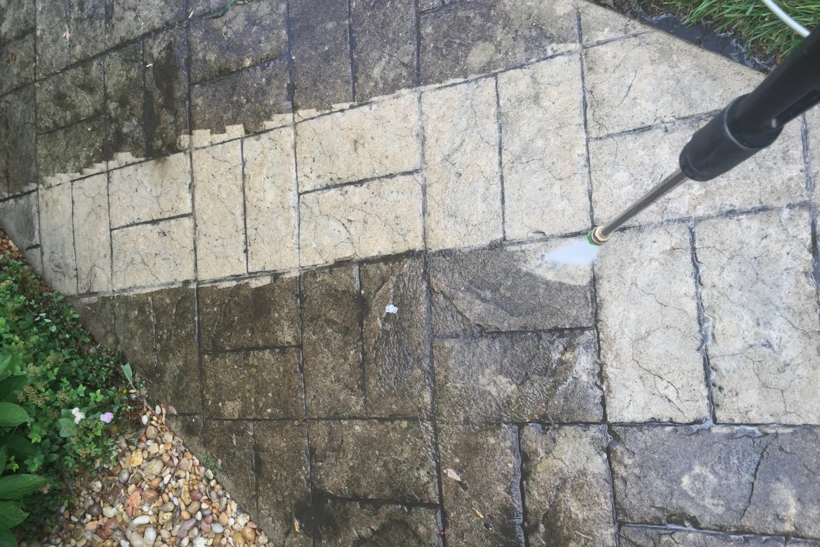 A pressure washing technician removing oil stains and hard-water deposits from a concrete driveway in Phoenix.