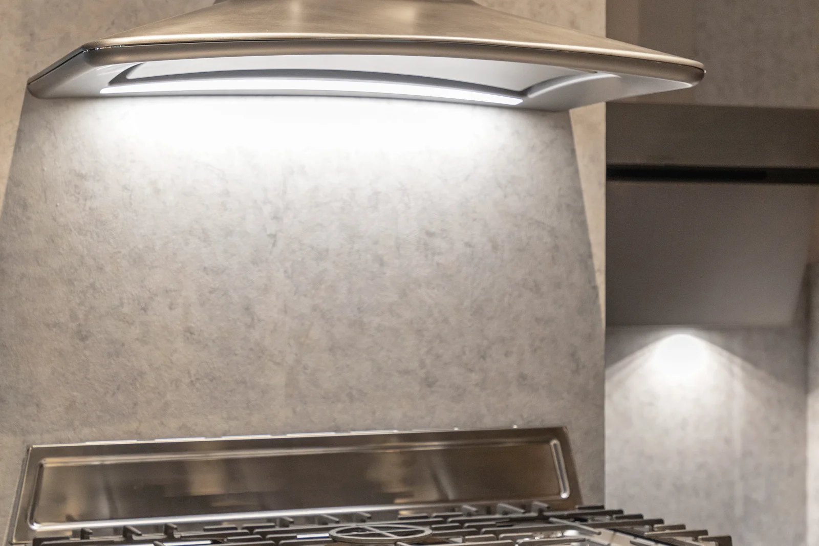 Range hood installation in Phoenix, Arizona — a finished stainless range hood installed over a gas range in a Phoenix kitchen.