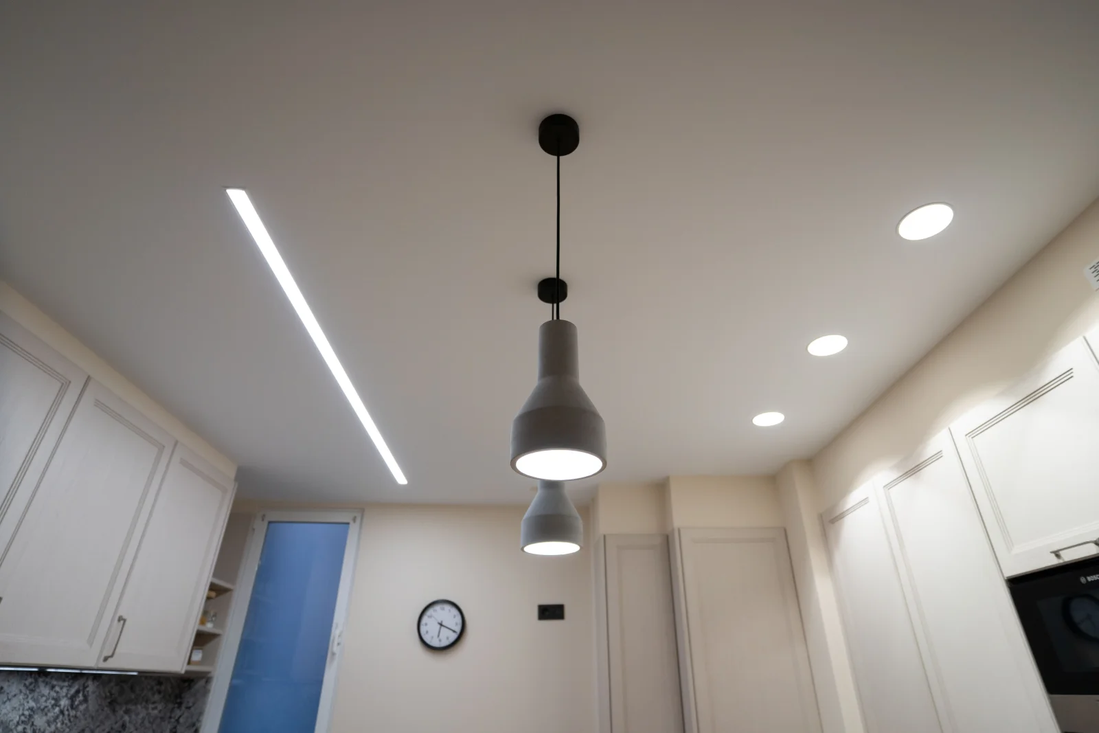 Recessed lighting installation in Phoenix, Arizona — a finished kitchen ceiling with evenly spaced recessed can lights and a pendant fixture.