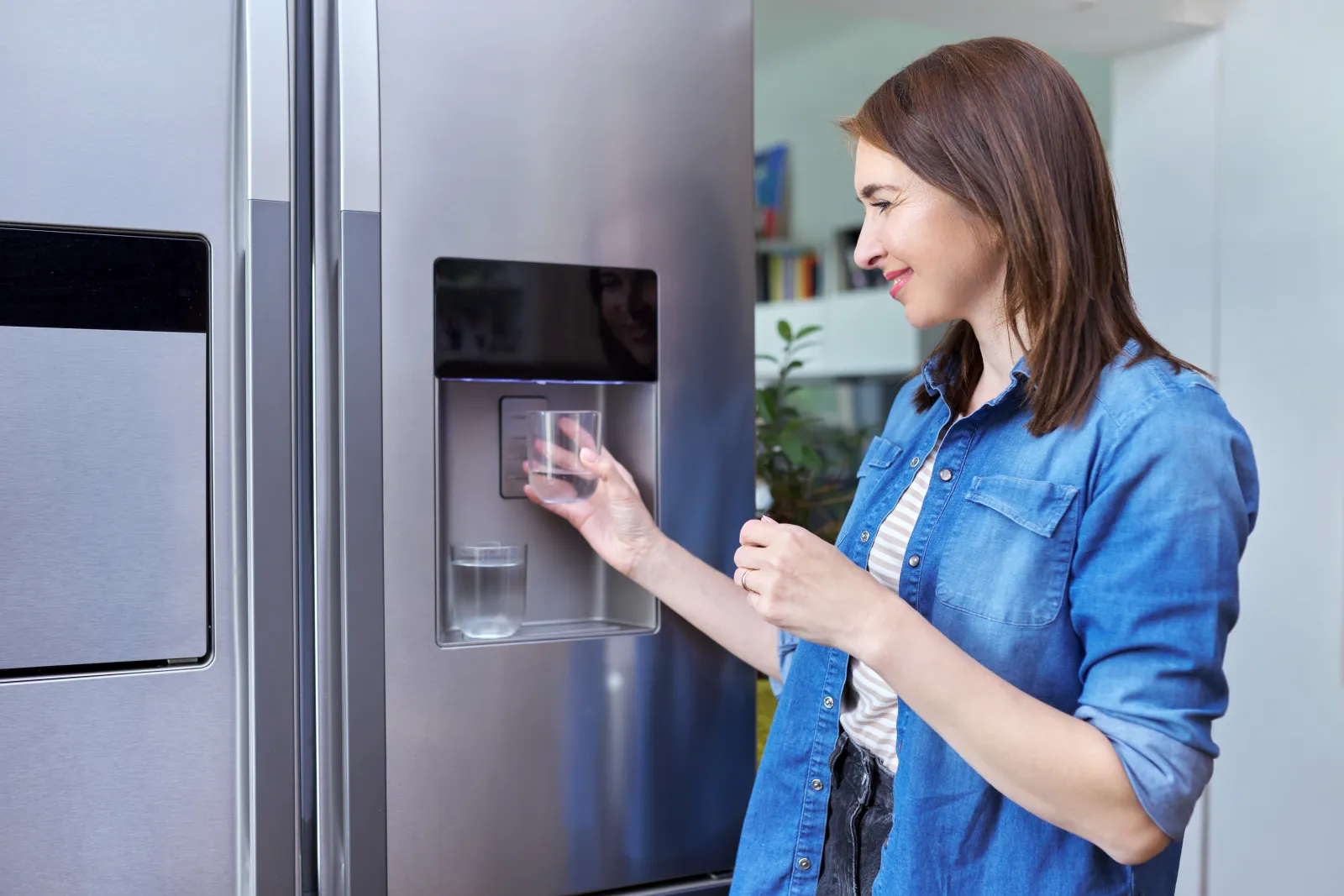 refrigerator-water-filter-replacement-phoenix-fridge-dispenser Refrigerator water filter replacement in Phoenix, Arizona, a homeowner using the water dispenser on a stainless steel side-by-side refrigerator.