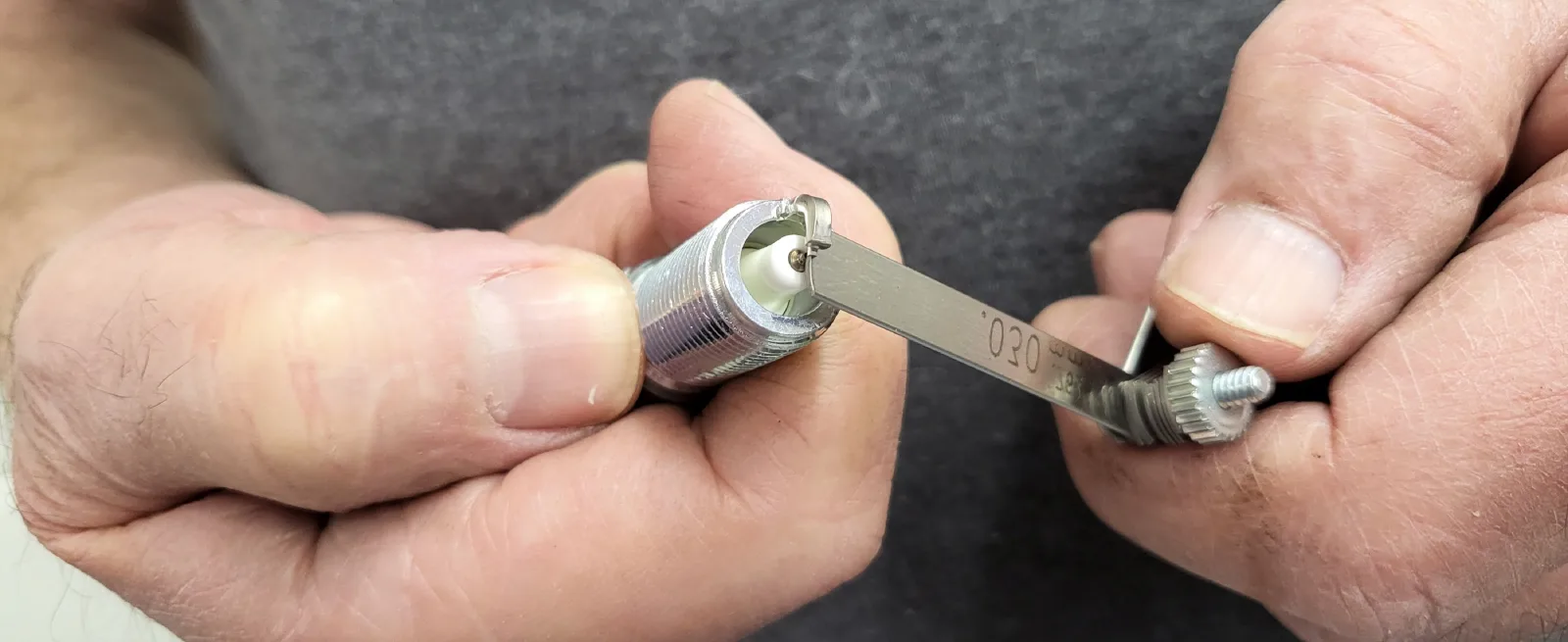 Rekeying service in Phoenix, Arizona — a locksmith's hands adjusting pin sizes in a lock cylinder using a pinning kit.