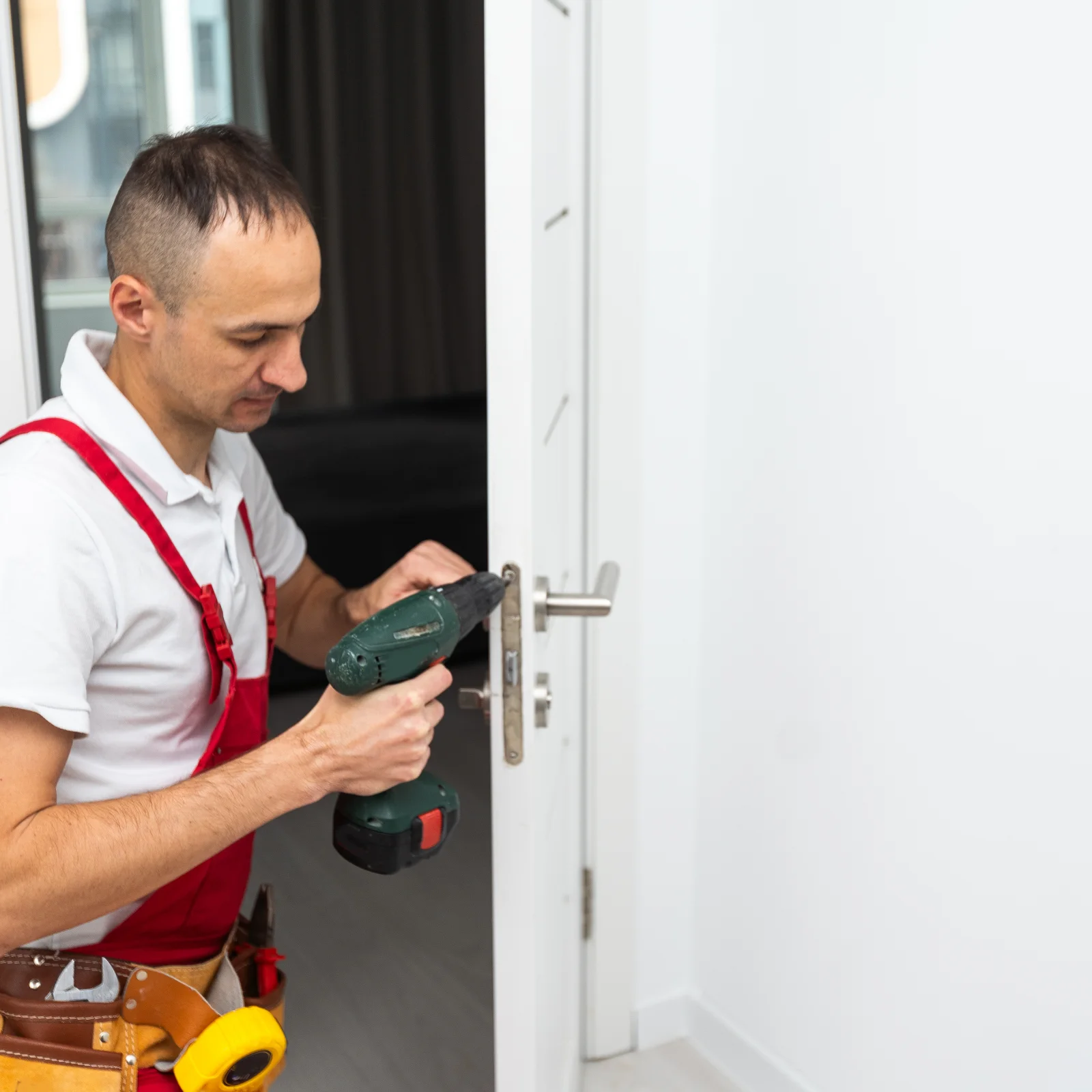 residential-locksmith-phoenix-deadbolt-install Residential locksmith in Phoenix, Arizona — a locksmith installing a new deadbolt on the front door of a stucco desert home.