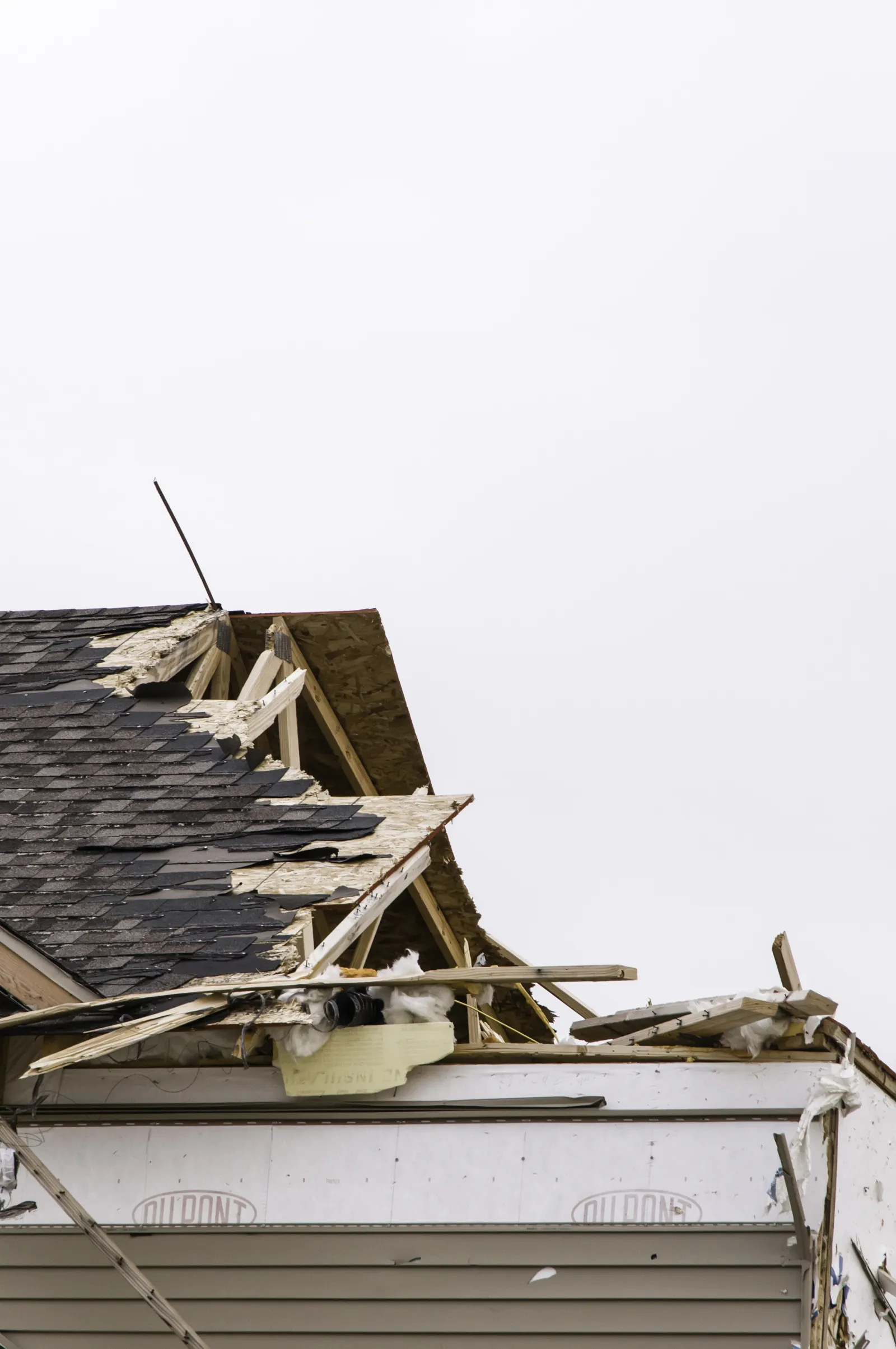 roof-storm-damage-repair-phoenix-wind-damage Wind-lifted and missing shingles and displaced roof tiles on a Phoenix home after a monsoon storm, the kind of wind and storm roof damage a vetted roofer repairs before water reaches the interior.