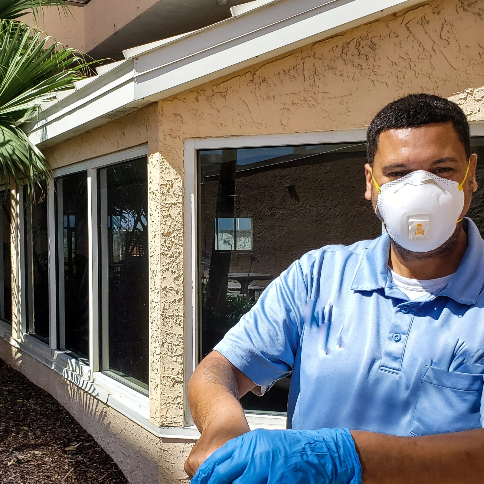 scorpion-control-phoenix-pest-control-pro Scorpion control pro in protective mask and gloves outside a stucco Phoenix, Arizona home, ready to inspect and treat for bark scorpions.