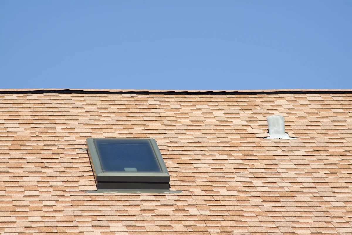 solar-tube-installation-phoenix-shingle-roof-dome Solar tube installation in Phoenix, Arizona — a low-profile solar tube dome and skylight set into a shingle roof under clear blue sky.
