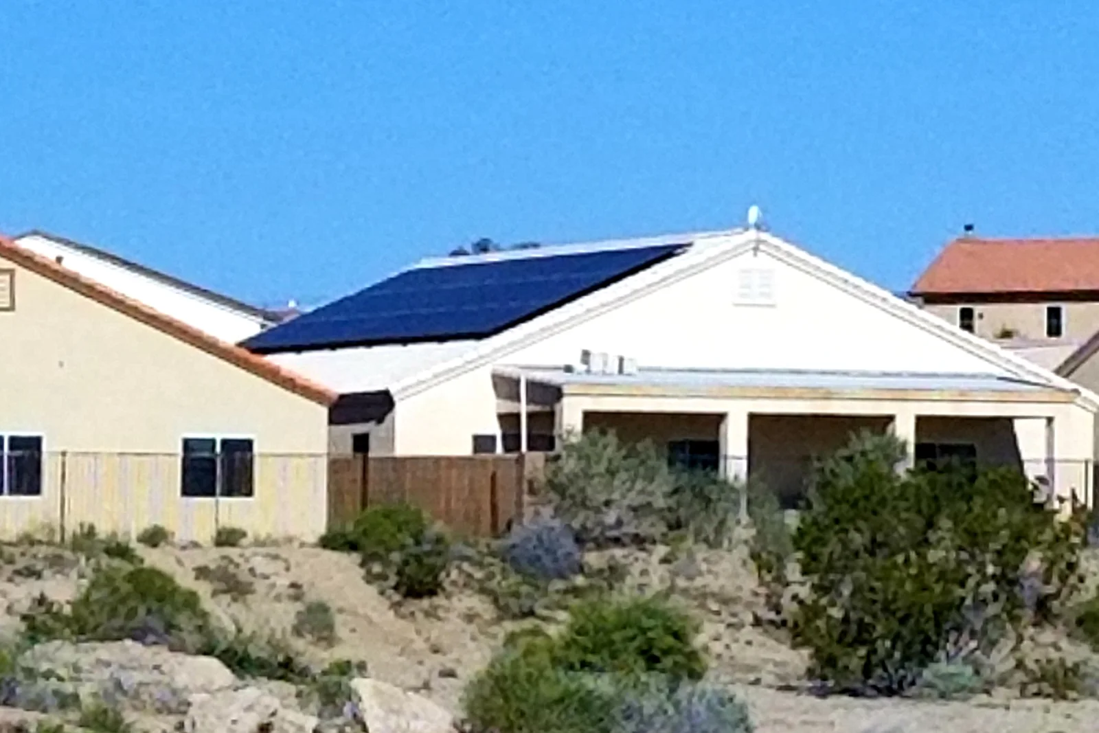solar-water-heater-service-phoenix-rooftop-collector-panels Rooftop solar thermal collector panels on a Phoenix, Arizona home showing the intense desert sun exposure that ages seals and collector fluid faster than in milder climates.