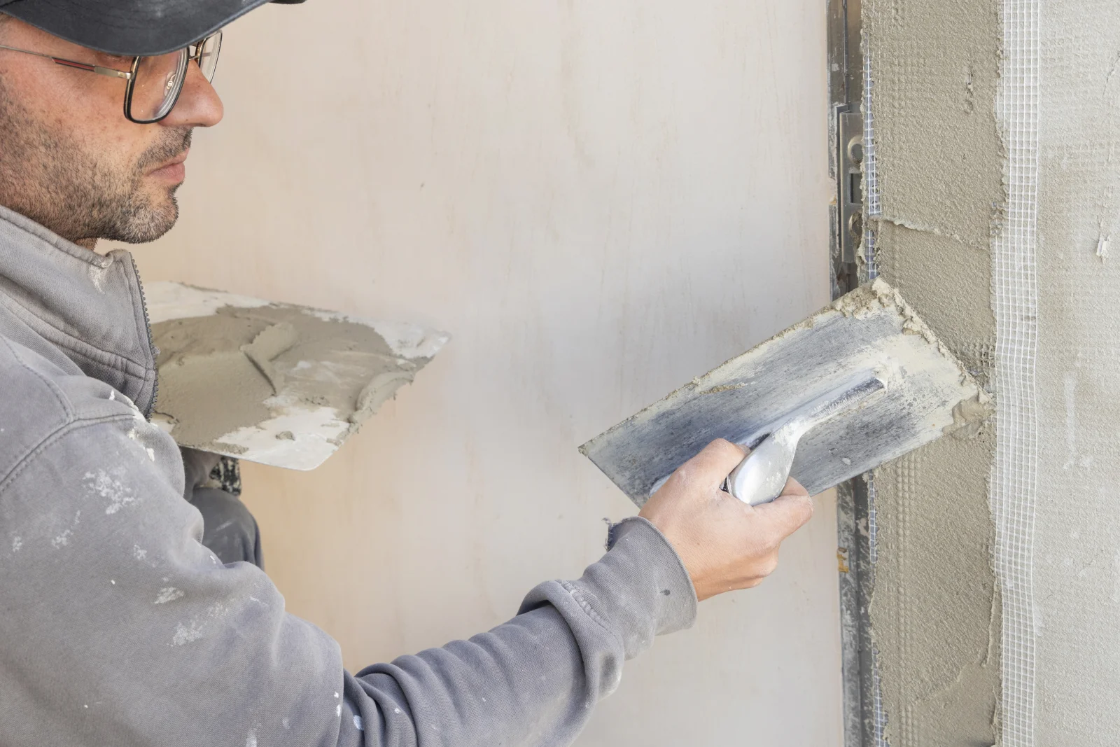 stucco-contractors-phoenix-finish-coat-trowel-work A stucco contractor troweling a smooth acrylic finish coat onto a wall in Phoenix.