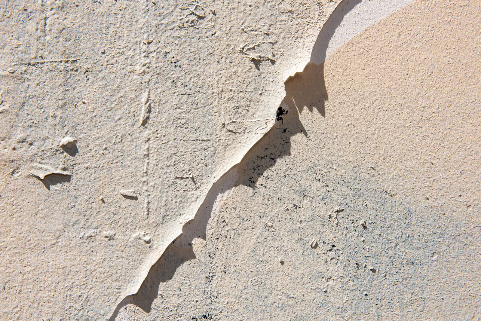 stucco-repair-phoenix-crack-triage A prominent diagonal crack running across a stucco wall, the kind of damage a Phoenix stucco repair pro triages as either cosmetic or a structural warning.