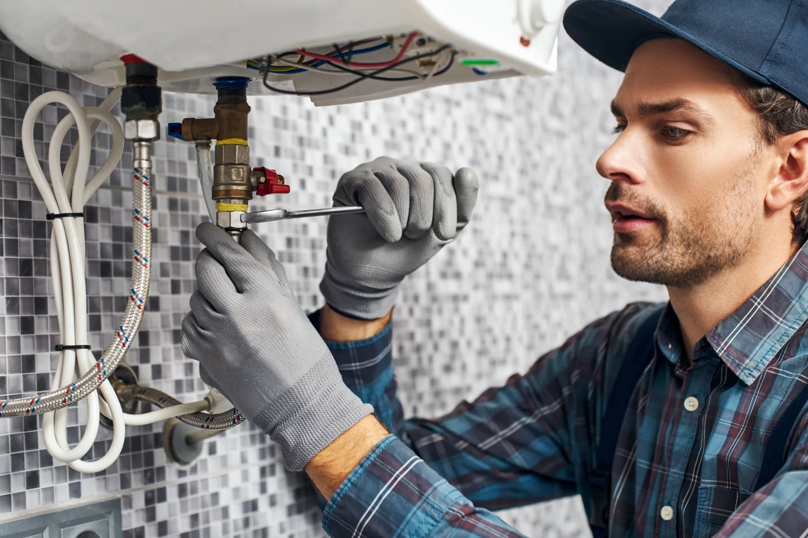tankless-water-heater-phoenix-hard-water-service A technician servicing the internal fittings of a tankless water heater to address hard water scale buildup in a Phoenix, Arizona home.