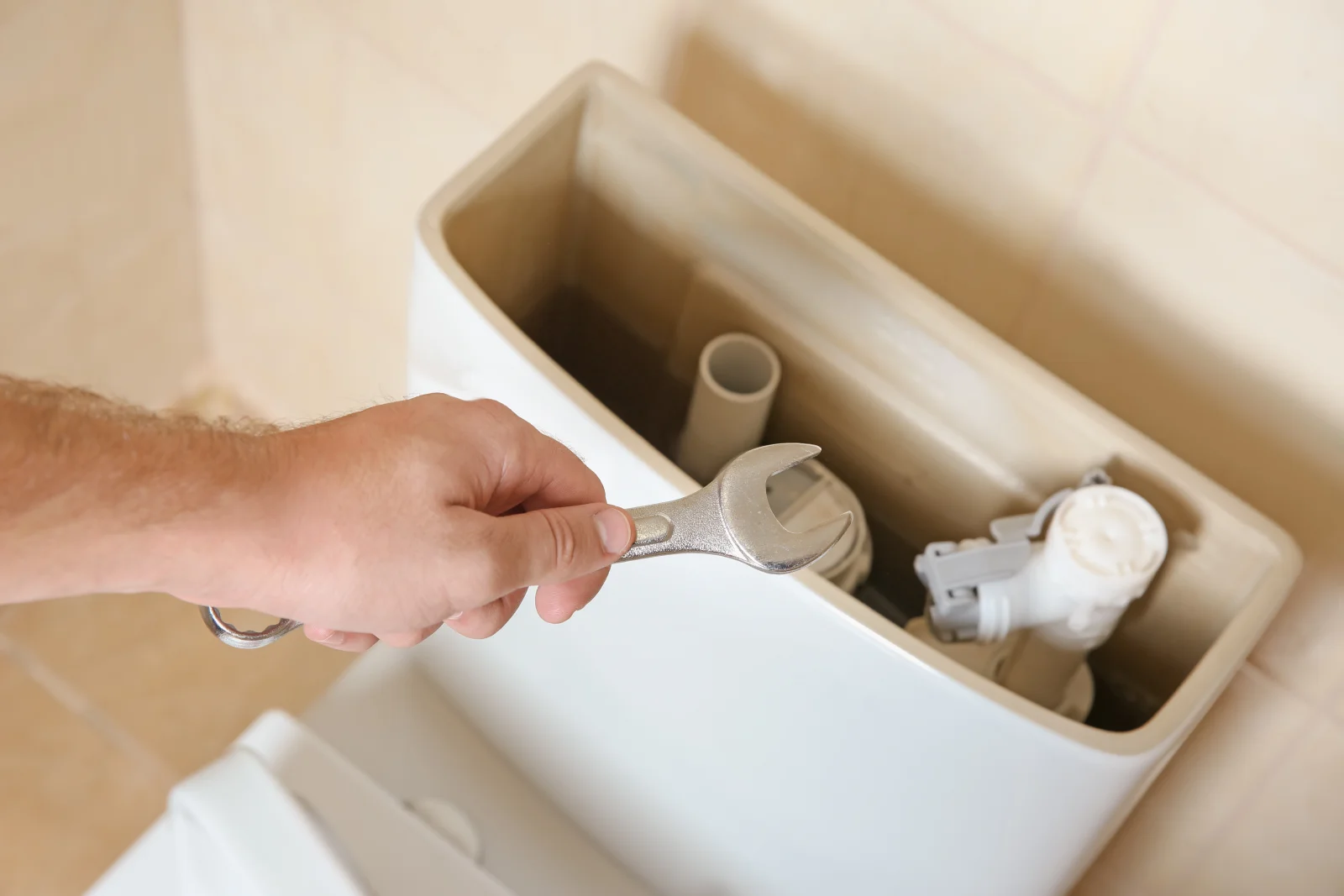 toilet-repair-phoenix-hard-water-mineral-scale Mineral scale buildup from Phoenix hard water inside a toilet tank, the kind of scale that wears out a fill valve and flapper seat and causes running and weak-flush toilets.
