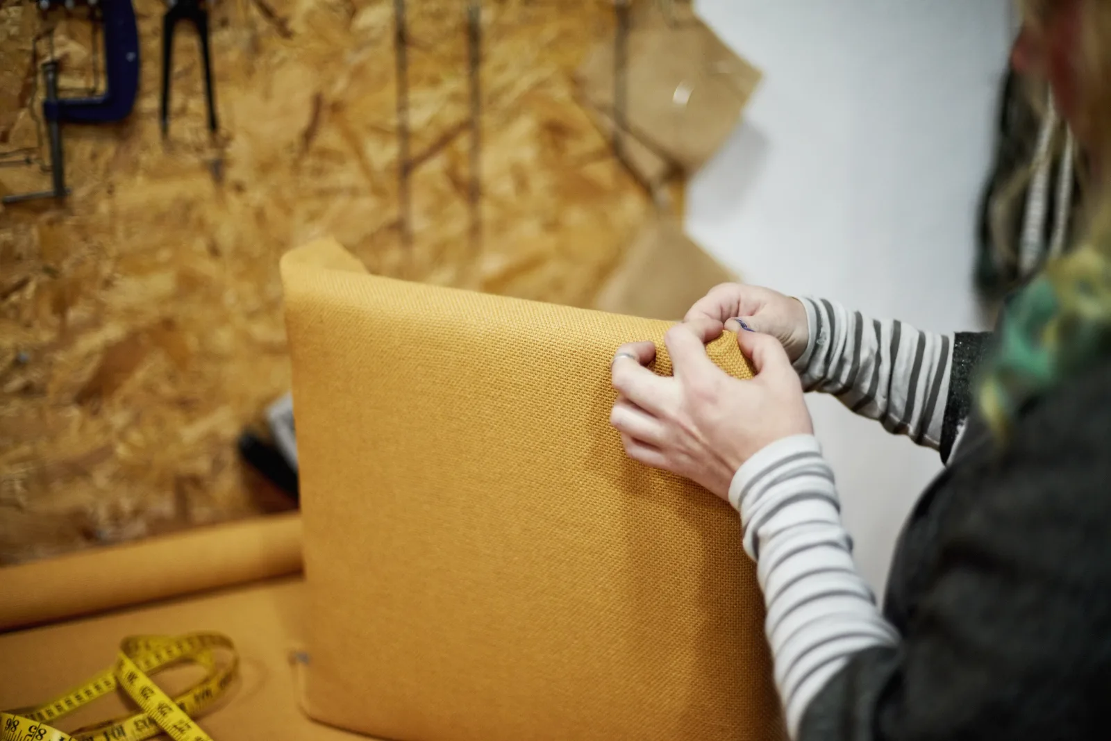 upholstery-repair-phoenix-fabric-stapling-chair An upholsterer stapling new fabric onto a chair frame in a Phoenix, Arizona workshop.
