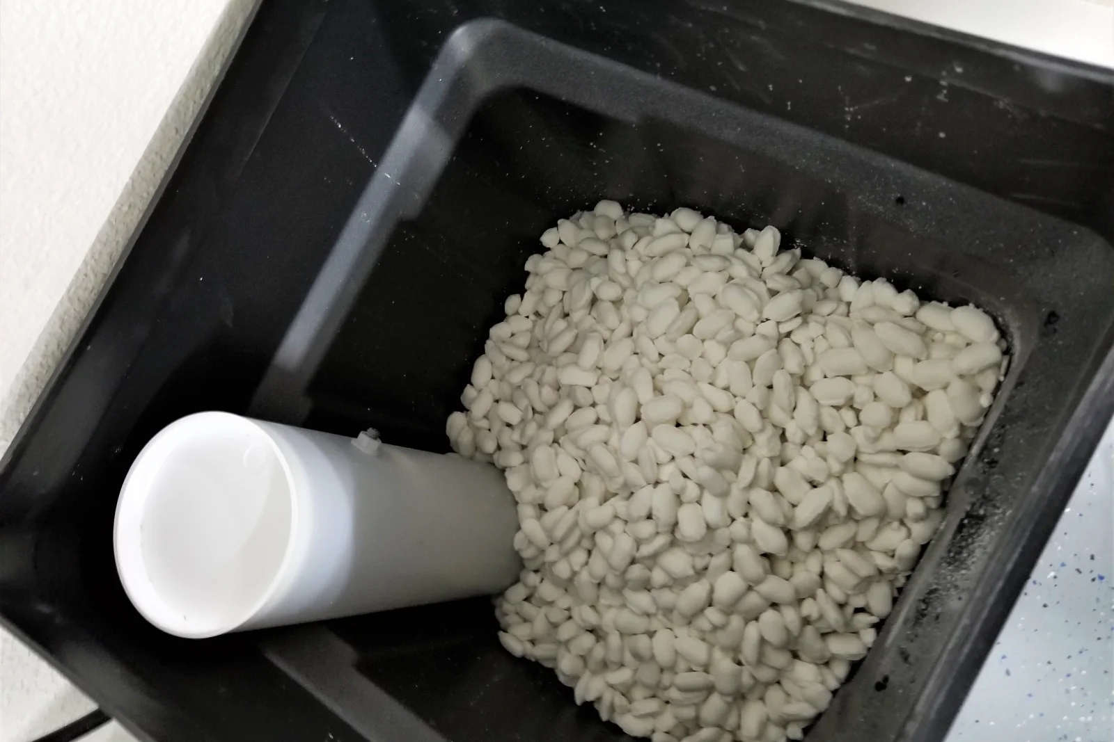 water-softener-installation-phoenix-brine-tank-salt-refill Water softener installation in Phoenix, Arizona — a brine tank being refilled with white salt pellets.