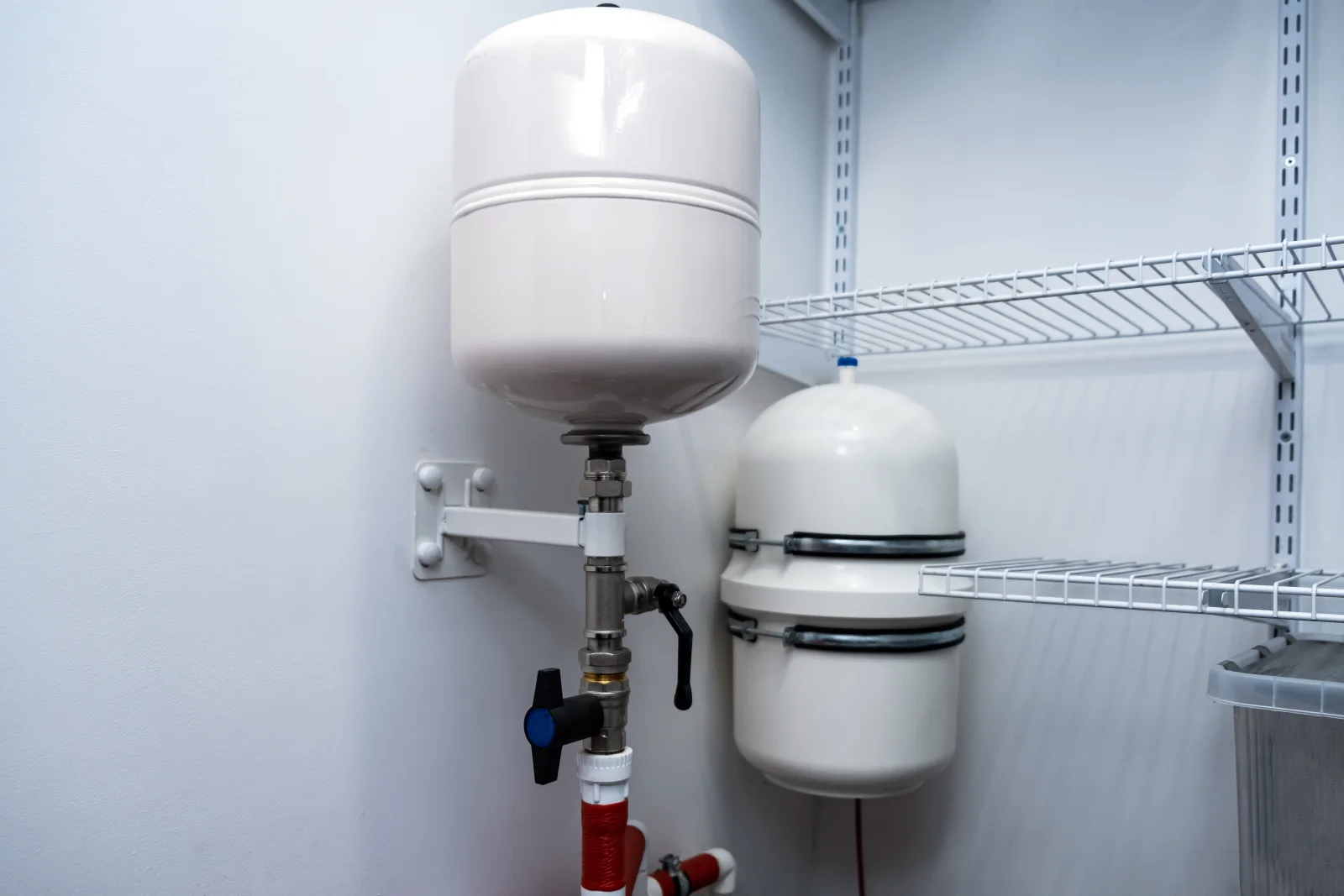 well-pump-repair-phoenix-pressure-tank Twin residential water pressure tanks mounted in a home utility closet, the kind of equipment a well pump pro inspects when water pressure drops.